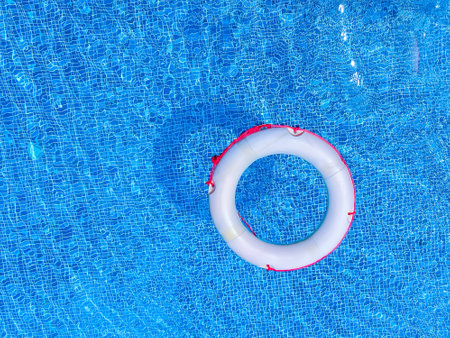 Inflatable ring floating in swimming pool on sunny summer day.の写真素材