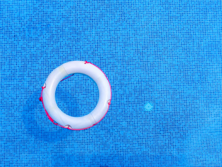 Top view of swimming pool with inflatable ring on blue water backgroundの写真素材