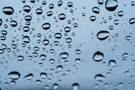 Rain drops cling to the car windshield, selective focus, soft focus.の写真素材