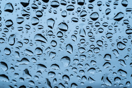 Rain drops cling to the car windshield, selective focus, soft focus.の写真素材