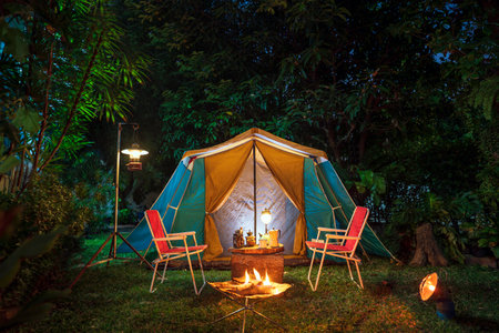 vintage cabin tent,  Antique oil lamp, retro chairs, Group of camping tents with outdoor coffee-making facilities on wooden tables in a forest camping area in the forest.の写真素材