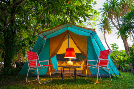 vintage cabin tent,  Antique oil lamp on a wooden table with retro chairs. at night in the  forestの写真素材