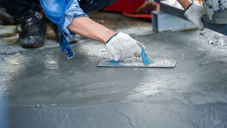 Bricklayer laying concrete To create a cement floor inside the house, soft focusの写真素材