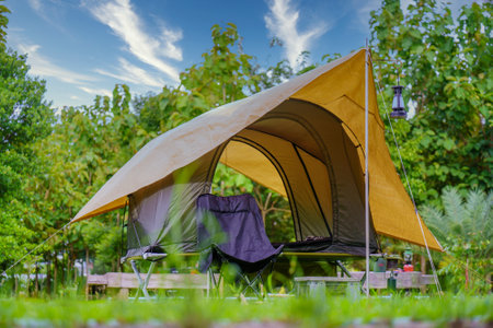 Camping tents,  Antique lanterns, retro chairs, and outdoor coffee-making facilities on  tables in a forestの写真素材
