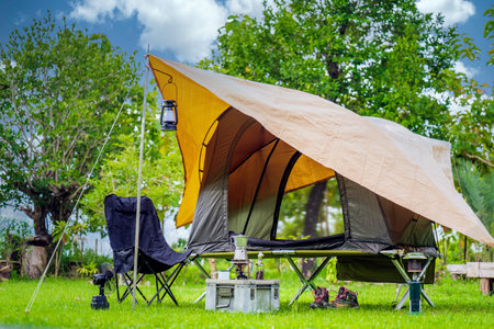 Camping tents,  Antique lanterns, retro chairs, and outdoor coffee-making facilities on  tables in a forestの写真素材