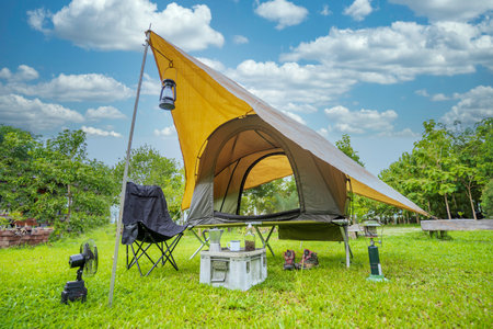 Camping tents,  Antique lanterns, retro chairs, and outdoor coffee-making facilities on  tables in a forestの写真素材