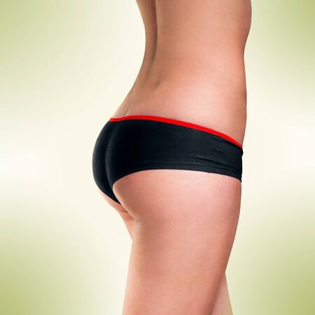 female bum in sports shorts on green backgroundの写真素材