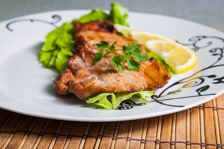 grilled pork with salad and lemon on plateの写真素材