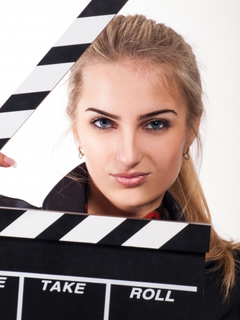 Portrait of beautiful girl with film slate in studio on white backgroundの写真素材
