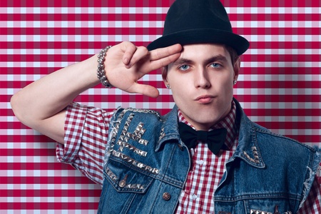 Pretty adult caucasian man near red checkered wall in studioの写真素材