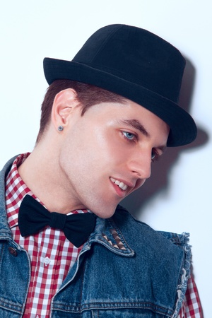 Nice man with bowtie looking away in studio near wallの写真素材