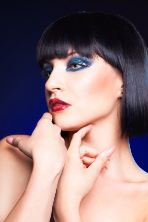 Cute brunette in studio on blue backgroundの写真素材