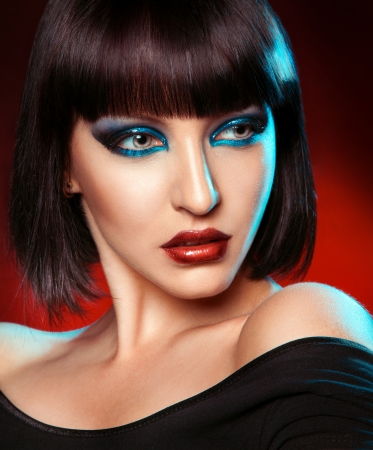 Portrait of pretty brunette with kare haircut in studio on red backgroundの写真素材
