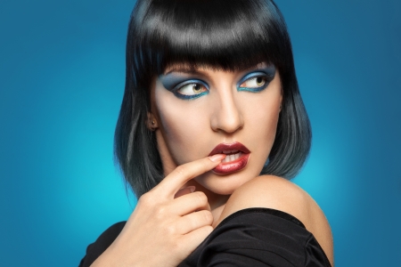 stunning young woman looking away in studio on blue backgroundの写真素材