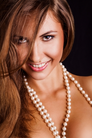 Young woman smiling on camera in studio on black backgroundの写真素材