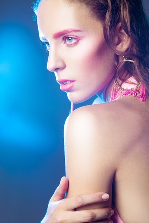 Adult pretty woman looking away in studio on blue backgroundの写真素材