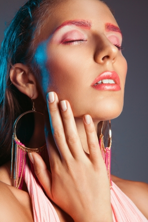 Close up portrait of gorgeous woman with pink make up in studio on gray backgroundの写真素材