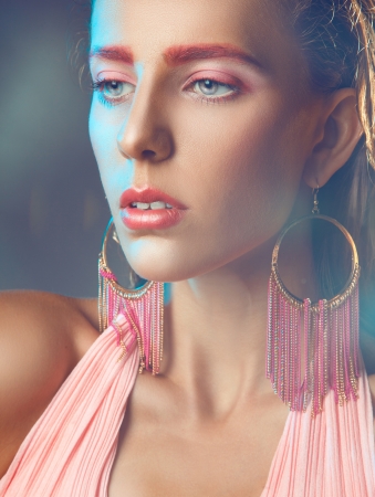 Woman with pink make up looking away in studioの写真素材