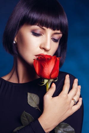 Attractive female with closed eyes and red roseの写真素材