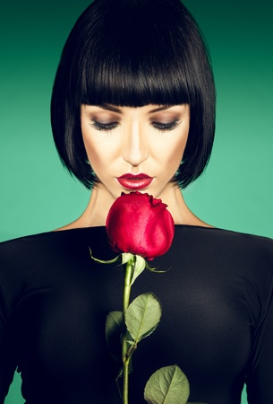 Charming brunette with der rose on green backgroundの写真素材