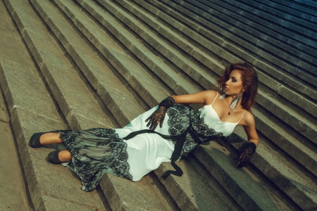 Attractive adult woman lying on stairsの写真素材