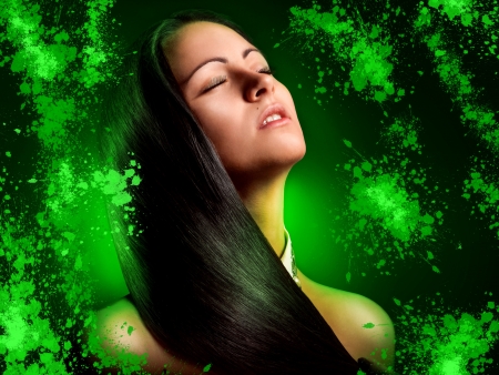 Pretty Brunette young woman with green splashes in studioの写真素材