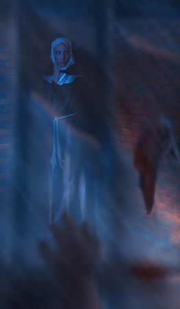 frightened girl nen behind broken glass near brick wallの写真素材