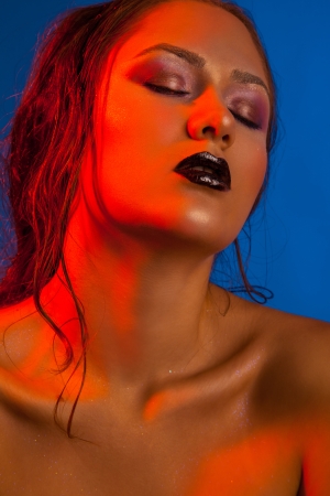 Glamour portrait of sensual woman in studio on blue backgroundの写真素材