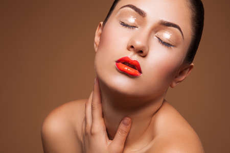 hot woman with wet make up in studio on brown backgroundの写真素材