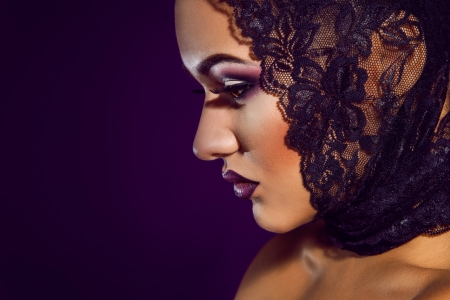 Cute young adult woman in studio on purple backgroundの写真素材