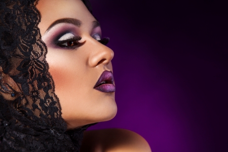 Half face photo of beauty woman with healthy skin in studio on purple backgroundの写真素材