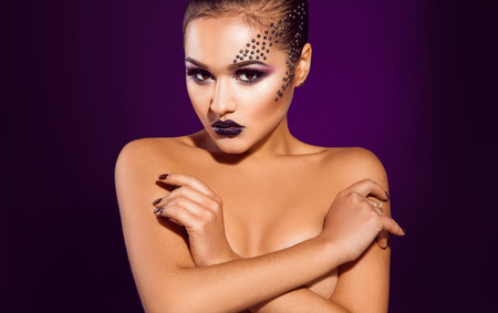 Horizontal photo of sexy adult female on purple background in studioの写真素材