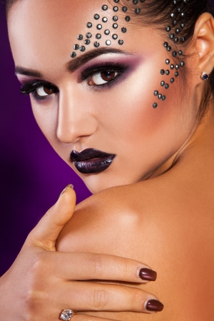 European adult girl with make up in studio on purple backgroundの写真素材