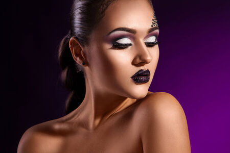 Sensual portrait of elegance adult woman in studio on purple backgroundの写真素材