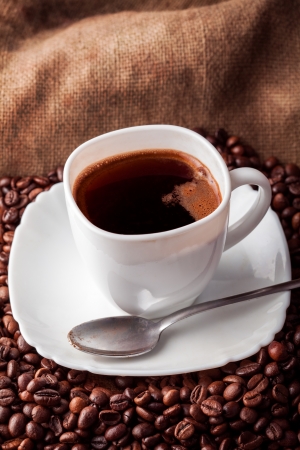 cup with coffee and spoon on cooffee beansの写真素材
