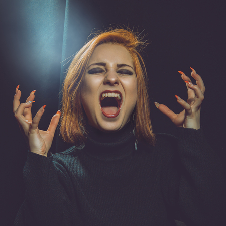 square dramatic photo of screamnig woman in studioの写真素材