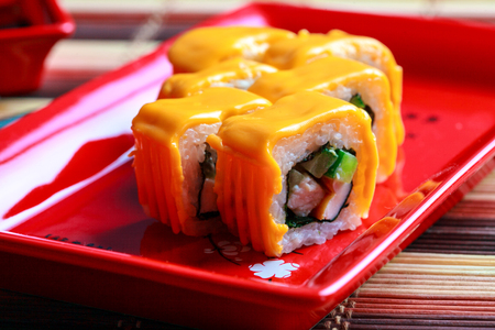 Close up photo of roll with cheese on top in red plateの写真素材