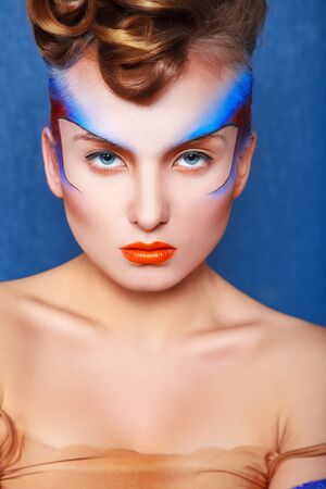 Adult cuacasian woman with creative make up looking at camera in studioの写真素材