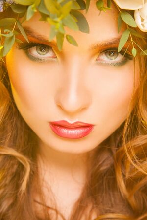 Close up picture of attractive woman with flowers in studioの写真素材