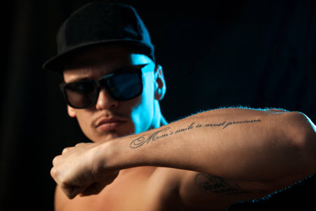 nice man with tattoo on hand in studio on black backgroundの写真素材