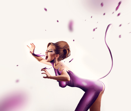 Panter woman in magenta paint on body screaming in studioの写真素材