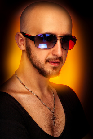 hairless male in sunglasses looking at camera  in studioの写真素材