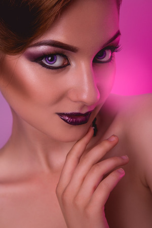 Portrait of voluptuous adult girl with make up on pink in studioの写真素材