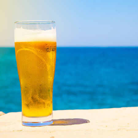 square photo of Glass of beer at summertime near seaの写真素材