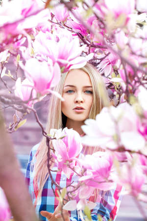 Glamour portrait of sexy young woman in blooming pink flowers. Spring timeの写真素材