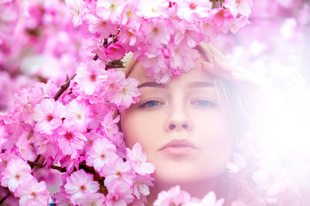 Stunning young blonde in bright pink flowers. Spring timeの写真素材