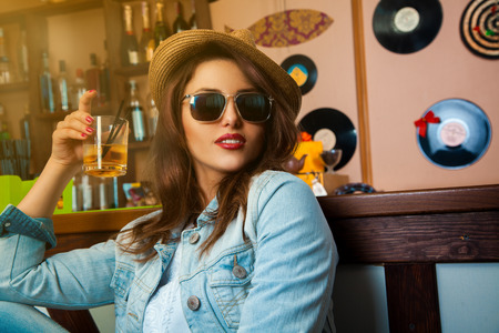 voluptuous young fashionable woman drink cocktail at bar. horizontal photo