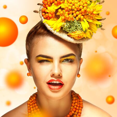 young fashion girl with beautiful makeup blink on orange backgroundの写真素材
