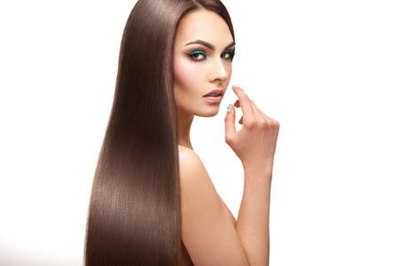 Charming lady with make up and perfect straight hair on white backgroundの写真素材