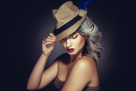 Lovely woman with greay hair color and beautiful makeup in stylish hat in studio